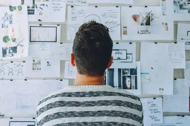 Man looking at papers on the wall